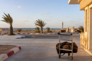 Chariot avec sac de voyage devant un petit terminal et la lagune de Dakhla