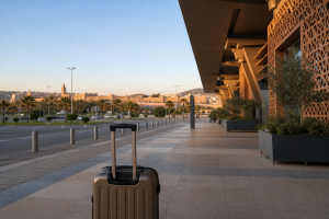 Valise devant un terminal marocain au soleil couchant avec Fès à l’horizon