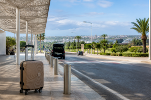 Valise sous un auvent d’aéroport face à un paysage urbain verdoyant de Rabat-Salé