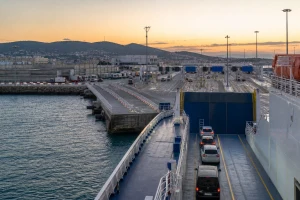 Ferry de passagers et véhicules arrivant dans un terminal portuaire marocain à l’aube, illustration originale MOP