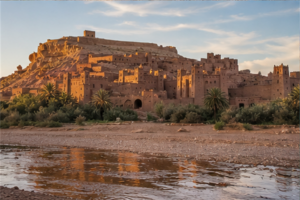 Ksar en terre d’Aït-Ben-Haddou éclairé par l’heure dorée au-delà de l’oued